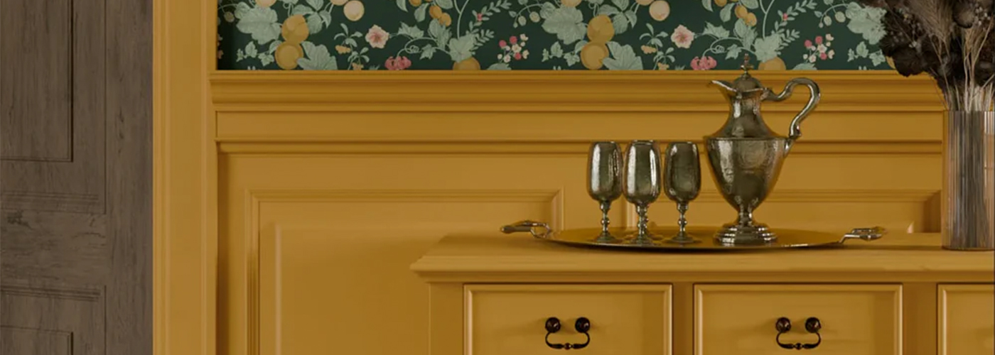 Rich golden ochre wall with vintage-inspired decor and a floral-patterned wallpaper accent.